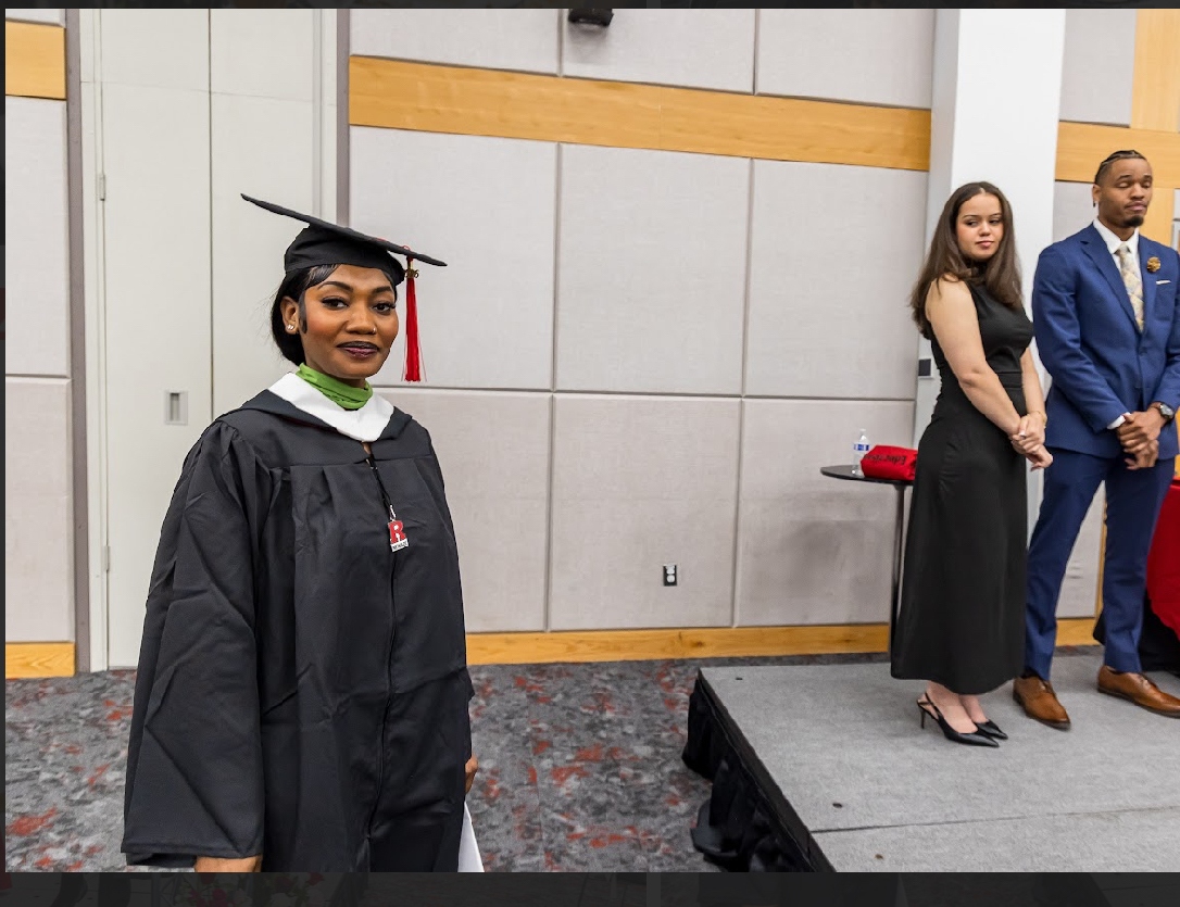 Maria Coates in graduation cap and gown with a green stole